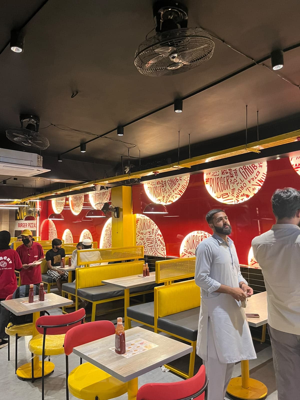 Yellow booths under the red wall and its hand-lettered roundels