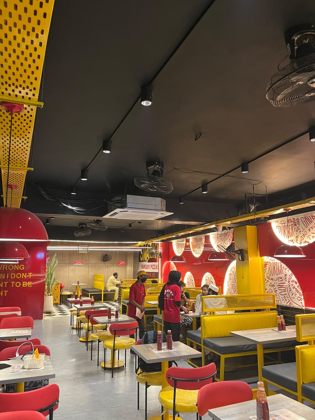 Inside Snacky on Wahdat Road — red walls, yellow booths